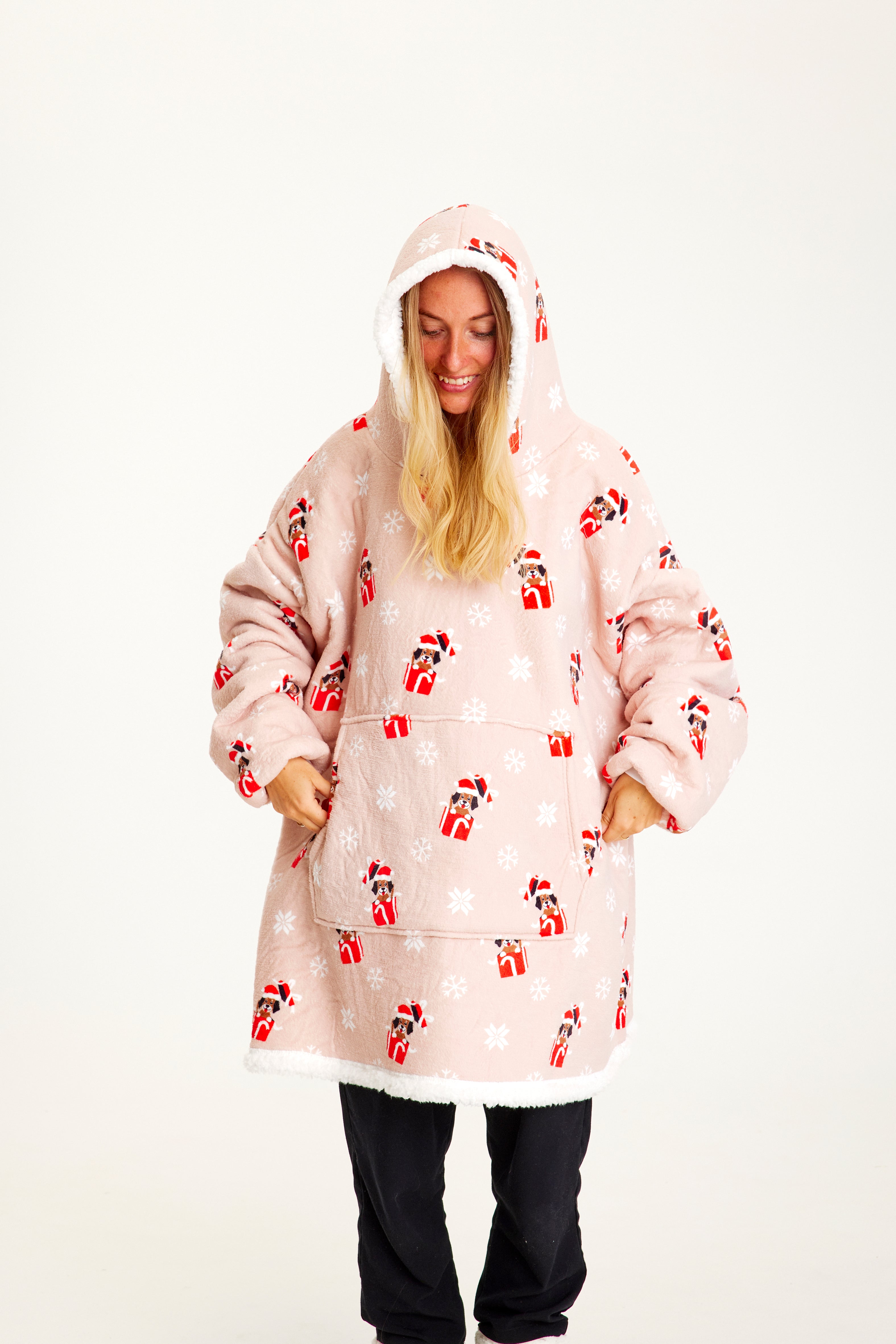 Una donna che indossa una felpa natalizia rosa con cappuccio.